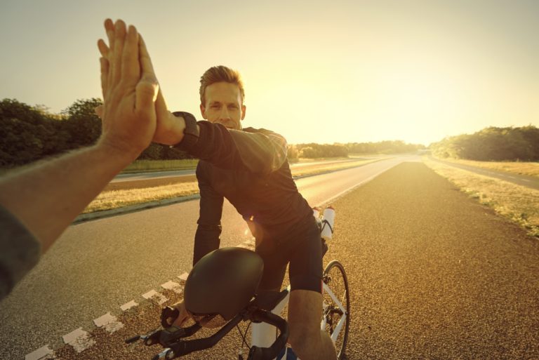 Man on bike giving a high five